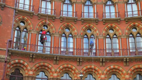 Trabajadores-Limpiando-Las-Ventanas-Del-Edificio-Victoriano-En-St-Pancras-International-En-Londres,-Inglaterra