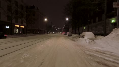 Toma-De-Conducción-Pov-A-Través-Del-Centro-De-Helsinki-Por-La-Noche-Con-Mucha-Nieve