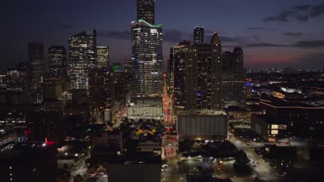 Luftaufnahme-Mit-Blick-Auf-Die-Milam-Street-Mit-Beleuchtetem-Hintergrund-Der-Skyline-Von-Houston---Zurückziehen,-Drohnenaufnahme