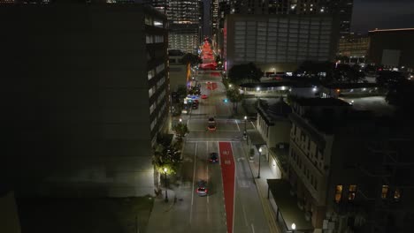 Aerial-view-tracking-cars-driving-towards-downtown-Houston,-evening-in-Texas,-USA