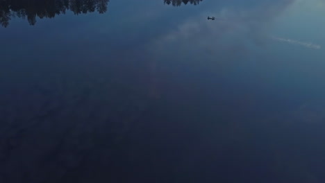 Morning-sky-reflecting-on-lake-water,-aerial-drone-view