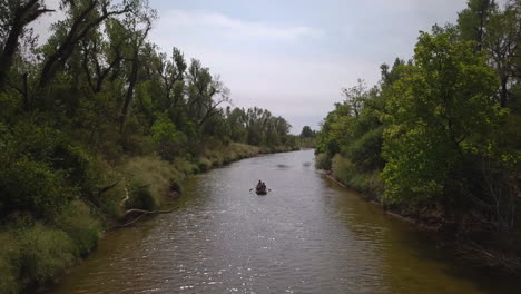Drone-shot-of-sailing-canoe-boat-on-a-river-in-Tulsa,-Georgia