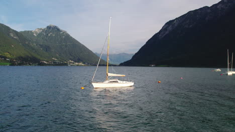 Aerial-view-sailboat-floating-in-idyllic-Achen-Lake-in-Achen-valley,-Pertisau,-push-in-shot