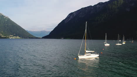 Aerial-view-sailboat-floating-in-idyllic-Achen-Lake-in-Achen-valley,-Karwendel-mountain-range