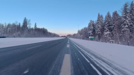 Timelapse-shot-driving-past-delivery-trucks-on-a-Helsinki-highway-in-the-snow