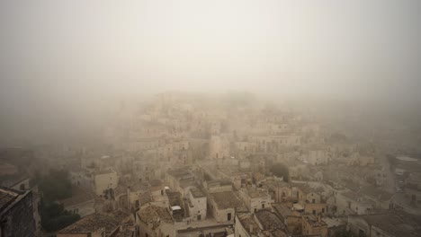 Slow-pan-to-the-left-filming-the-old-city-of-Matera-covered-in-mist-in-4k