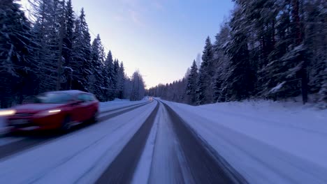 POV-driving-shot-alongside-a-snowy-forest-in-Helsinki