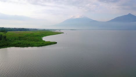 Vista-De-Drones-Del-Lago-Rawa-Pening-Con-Montañas-En-El-Fondo,-Indonesia