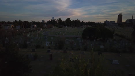 Aerial-establishing-shot-of-a-cemetery-at-dusk
