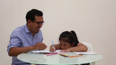 Indonesien---18.-Dezember-2022:-Süßes-Asiatisches-Kleines-Mädchen,-Das-Lernt,-Mit-Seinem-Vater-Zu-Schreiben