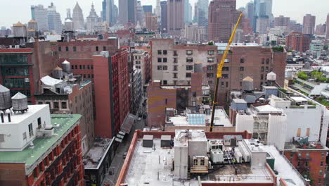 Aerial-View,-Soho-Neighborhood-of-Manhattan-New-York-City-USA-and-Crane-Machine,-Revealing-Drone-Shot