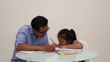Indonesia---18-De-Diciembre-De-2022:-Linda-Niña-Asiática-Estudiando-Para-Escribir,-Coloreando-Un-Libro-Con-Su-Padre