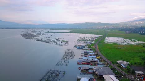 Drone-view-of-Rawa-Pening-lake-with-fish-cage-and-railroads-on-side,-Ambarawa