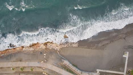 Aerial-top-to-bottom-drone-shot-over-beach-break,-Malaga-Candado-Spain