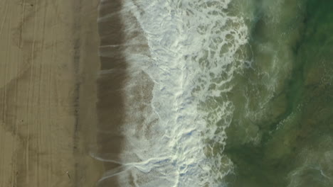 Drone-top-shot-of-sea-water-waves-hits-beachside