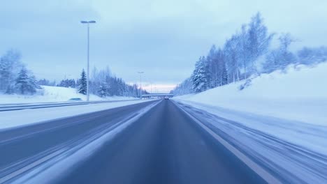POV-driving-shot-traveling-across-a-cleared-snowy-highway-in-Helsinki