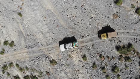 Aerial-top-angle-shot-of-car-driving-in-the-rocky-road-of-mountain
