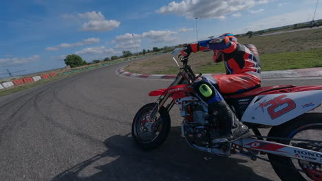 FPV-drone-pursuit-behind-motorcycle-rider-on-racetrack-speeding-away-pulling-wheelie
