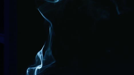 Smoke-of-cigarette-is-rising-against-black-background,-mystic-atmosphere-with-porch-smoke-swirls