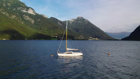Aerial-view-sailboat-floating-in-idyllic-Achen-Lake-orbiting-Achen-valley,-Pertisau