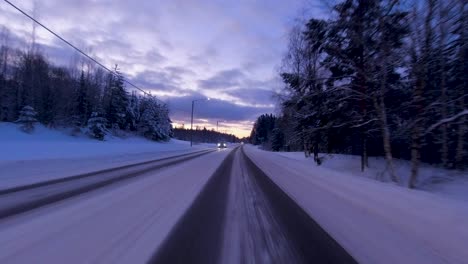 POV-shot-driving-along-a-rural-Helsinki-road-with-tracks-created-in-the-snow