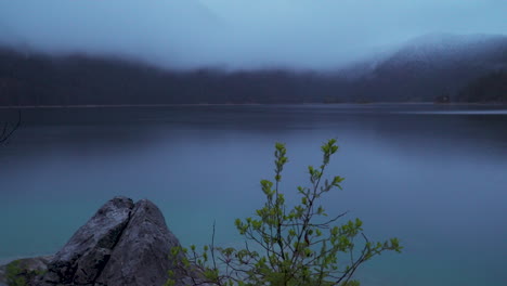 Low-misty-cloud-over-lake-Eibsee-and-Zugspitze-mountain-landscape-in-early-morning-light
