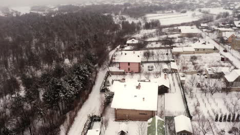 Aerial-Drone-Shot-Circling-360-Degrees-around-a-Snow-Covered-Home-in-the-Winter-near-Moldova-Romania