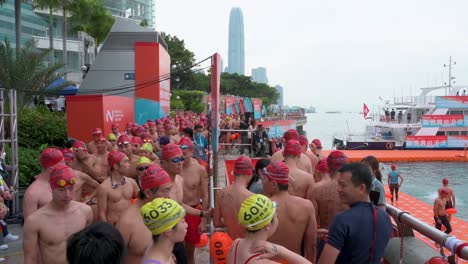 Participantes-Chinos-Y-Entusiastas-De-La-Natación-Caminan-Hasta-La-Línea-De-Salida-Durante-La-Competencia-Anual-De-Natación-New-World-Harbour-Race-En-Hong-Kong