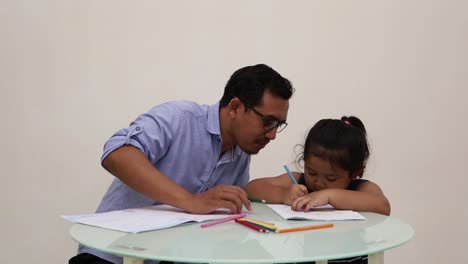Indonesien---18.-Dezember-2022:-Kleines-Asiatisches-Mädchen,-Das-Mit-Seinem-Vater-Schreibt,-Um-Zu-Schreiben