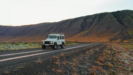 White-Land-Rover-Defender-Durante-La-Carretera-Interior-De-La-Campiña-Islandesa-Durante-La-Puesta-De-Sol-De-La-Hora-Dorada