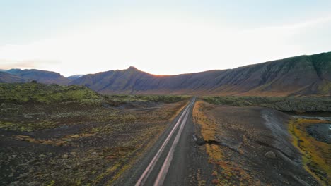 Todoterreno-Blanco-Conduciendo-Por-Una-Carretera-Rural-En-Un-Asombroso-Y-Colorido-Paisaje-Volcánico-De-Islandia-Durante-La-Puesta-De-Sol