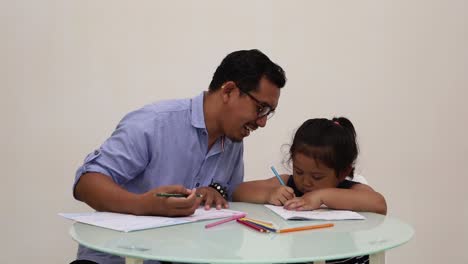 Indonesia---18-De-Diciembre-De-2022:-Niña-Asiática-Estudiando-Para-Escribir,-Coloreando-Un-Libro-Con-Su-Padre