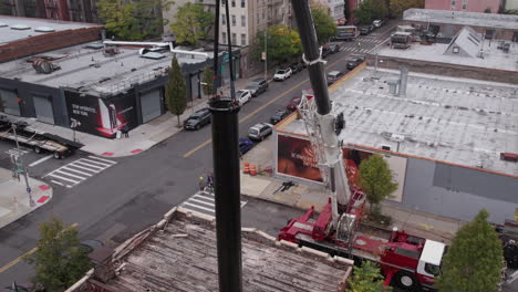 Aerial-View-of-Crane-Lifting-Steel-Support-For-New-Advertising-Billboard-in-Suburbs-of-Brooklyn-NYC-USA