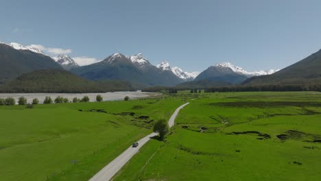 Car-driving-on-scenic-road-to-Paradise-in-lush-green-mountain-valley,-New-Zealand