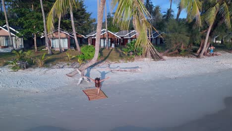 yoga-girl-Stand-on-one-leg-Fitness-exercise-palmtree-at-sunset-seacret-beach