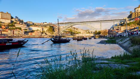 Porto-Zeitraffer-Des-Flusses-Douro-Mit-Booten-Und-Der-Berühmten-Wahrzeichenbrücke-Dom-Luís-I-Im-Hintergrund