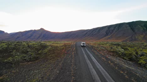 Weißer-Land-Rover-Verteidiger-Fährt-Bei-Sonnenuntergang-In-Die-Vulkanische-Landschaft-Im-Goldenen-Kreis-Von-Island