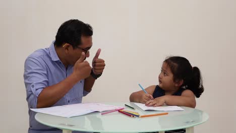 Indonesia---Dec-18,-2022-:-asian-little-girl-studying-to-write,-coloring-a-book-with-his-dad