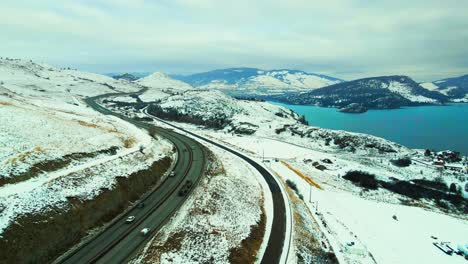 Winter-Travel:-High-Traffic-on-Okanagan-Highway-97-with-Stunning-View-of-Wood-Lake-and-Snow-Covered-Mountains