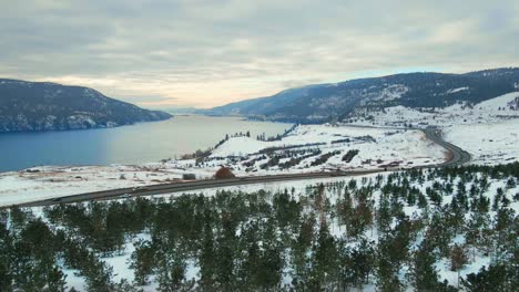 Snowy-Winter-Wonderland:-Aerial-View-of-Central-Okanagan-Landscape,-Highway,-and-Wood-Lake