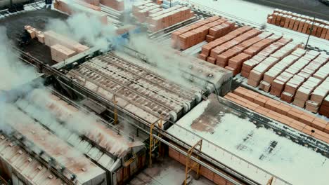 Overhead-shot-of-industrial-dry-kilns-and-large-stacks-of-plywood-on-sawmill-production-site-in-Canada
