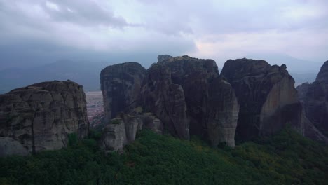 Meteora-Felsformation-In-Griechenland-Mit-Orthodoxen-Klöstern-Mit-Stadtlichtern,-Die-über-Felsbrocken-Sichtbar-Sind