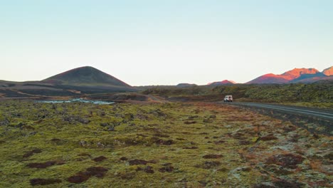 Toma-Aérea-De-Drones-De-Land-Rover-Defender-Blanco-Conduciendo-A-Través-De-Un-Colorido-Paisaje-Volcánico-En-Islandia