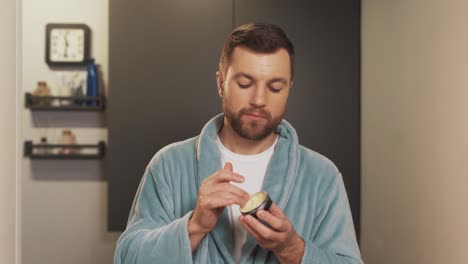A-stylish-man-applies-a-product-to-his-beard-in-the-bathroom
