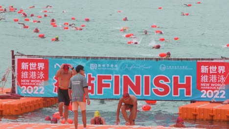 Teilnehmer-Und-Schwimmbegeisterte-überqueren-Die-Ziellinie,-Wenn-Sie-Am-Jährlichen-Schwimmwettbewerb-New-World-Harbour-Race-In-Hongkong-Teilnehmen