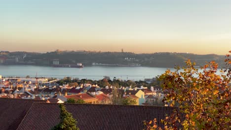 Aerial-dolly-of-river-tagus-among-pine-trees-in-sunny-daytime-in-Lisbon-with-Cristo-Rei-and-bridge-25th-in-background