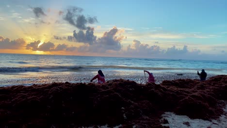 Local-Workers-Removing-Sargassum-Seaweed-At-The-Beach-In-Playa-del-Carmen-At-Sunset-In-Mexico