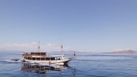 Cara-Komodo-Inselgruppe-Hüpfendes-Tourboot-Mit-Touristen,-Die-Im-Meer-Kreuzen---Umlaufende-Antenne