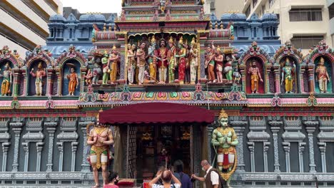 Tilt-up-view-of-devotees-praying-outside-Sri-Krishnan-Temple,-a-Hindu-Temple-at-Waterloo-Street,-Bugis,-Singapore