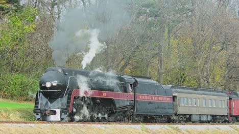 A-View-of-a-Steam-Passenger-Train-Stopped-on-a-Cold-Fall-Day-With-Lots-of-Smoke-and-Steam